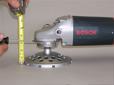 Measure the distance from the surface of the work to the top of the bearing housing of the grinder.